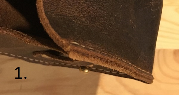Seam on leather pouch where the inside faces of each piece are against each other, so that the stitching is visible on both sides of the seam.