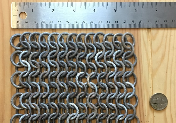 3D printed chainmail with a ruler and a USA five cent nickel for size reference.