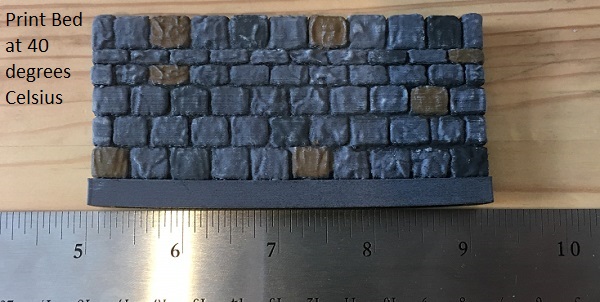 3D printed dungeon wall tile printed in PLA with a print bed temperature of 40 degrees Celsius, showing the warping of the bottom