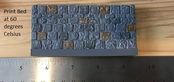 3D printed dungeon wall tile printed in PLA with a print bed temperature of 60 degrees Celsius, showing the slight warping at the bottom