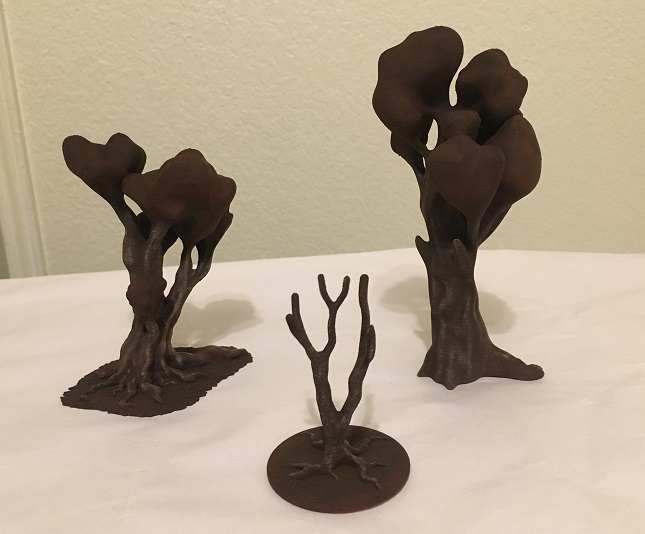 3D printed trees with bark details painted on the trunks.