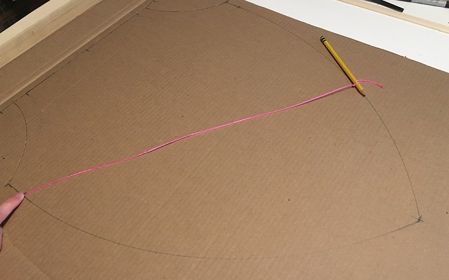 Drawing the pattern for a heater shield on cardboard